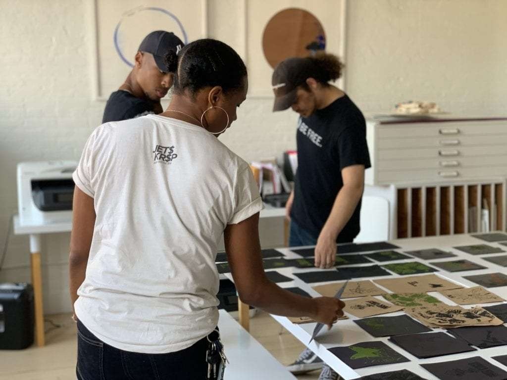 Artist Ash Arder and Assembly Peer Leaders pull screen-printed vinyl album sleeves—created using Black sand, soil and Fine Turf “Green Grass”. (image 5511) Over the course of Arder’s two-month residency, the artist regularly met with Assembly Peer Leaders to discuss the relationship between Black culture, music, and plant life. Using Recess’ in-house print shop, Assembly youth screen-printed record sleeves marrying the music of artists like Al Jarreau and Lenny Kravitz.Artist Ash Arder and Assembly Peer Leaders pull screen-printed vinyl album sleeves—created using Black sand, soil and Fine Turf “Green Grass”. (image 5511) Over the course of Arder’s two-month residency, the artist regularly met with Assembly Peer Leaders to discuss the relationship between Black culture, music, and plant life. Using Recess’ in-house print shop, Assembly youth screen-printed record sleeves marrying the music of artists like Al Jarreau and Lenny Kravitz.