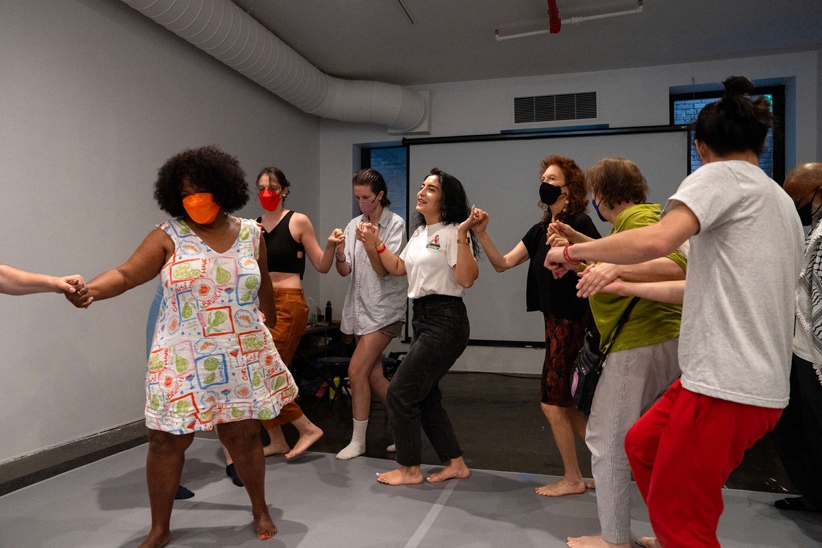 people dancing and holding hands in a circle 