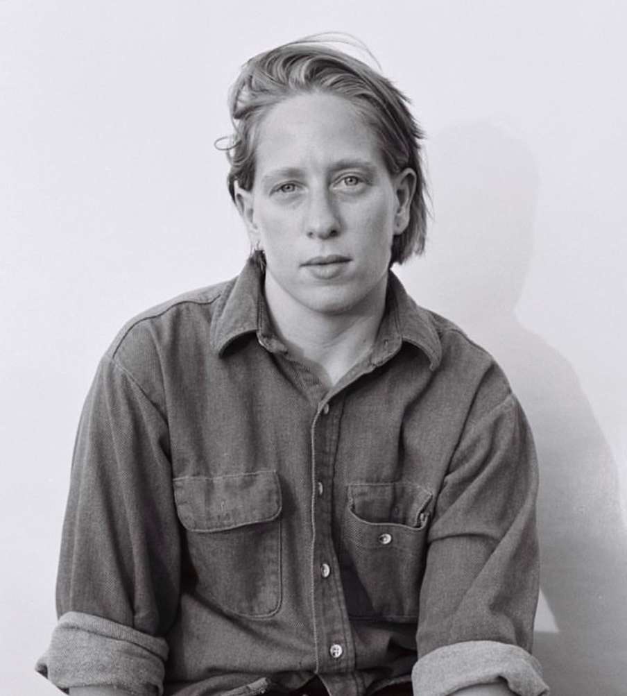 person on white backdrop with grey shirt 